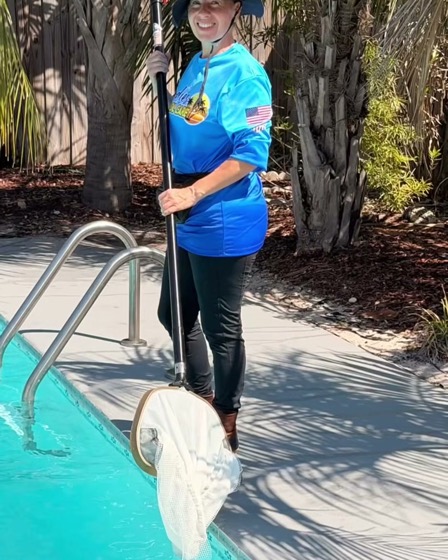 A Goodies family member with a leaf net beside a pool